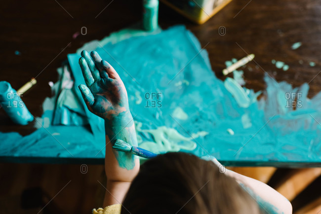 Young girl painting herself and table