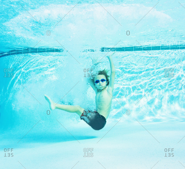 Boy sinking to the bottom of a pool stock photo OFFSET