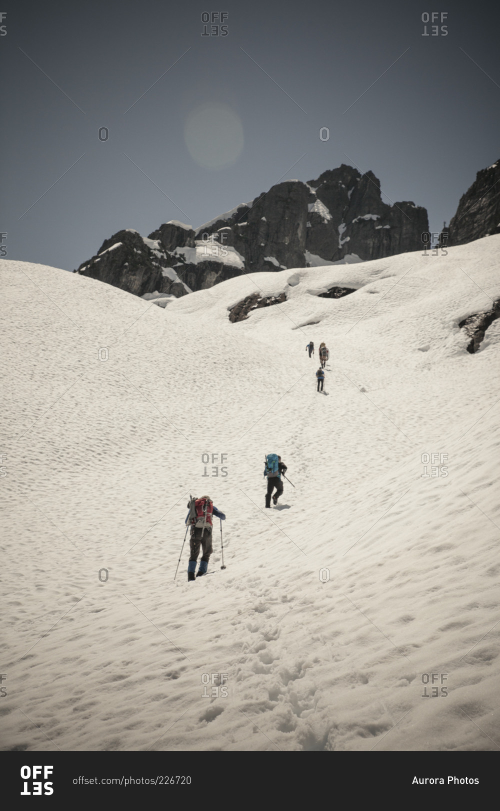 Six climbers cross a snow patch en route to climb Trio Peak in British Columbia, Canada