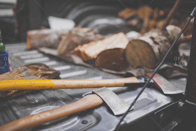 Two axes and firewood on the tailgate of a pickup truck