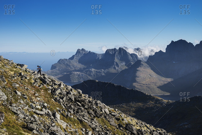 Female hiker ascending a rocky ridge on Branntuva