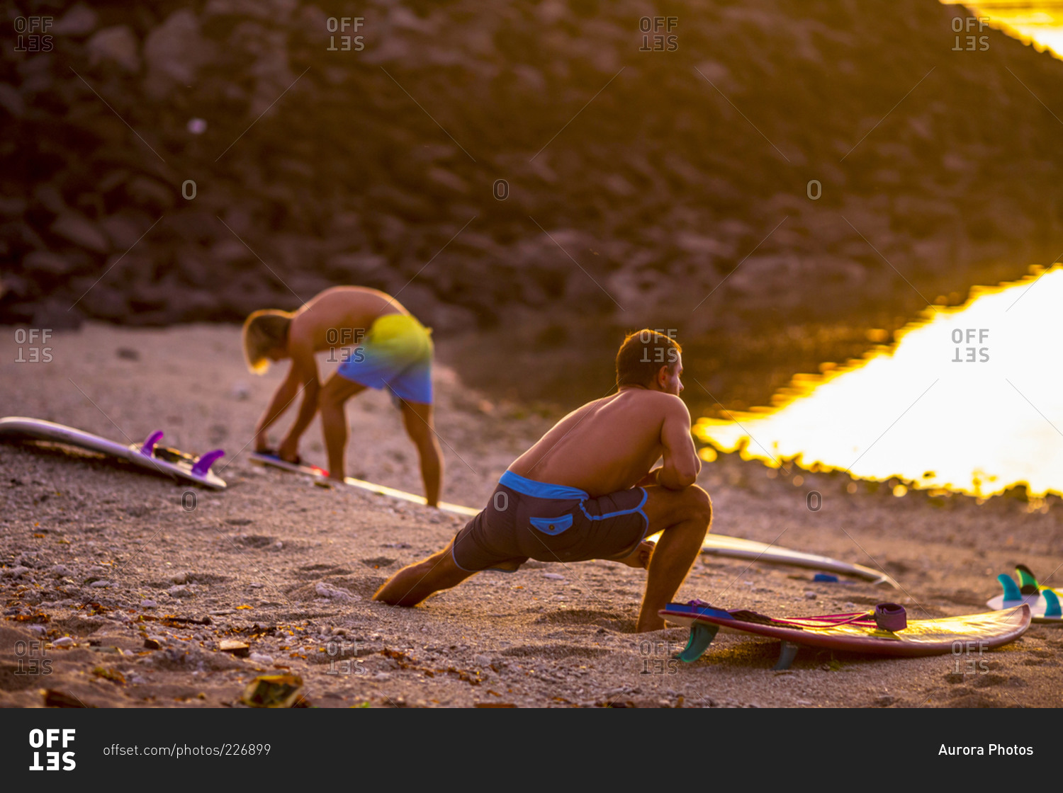 Surfers stretching on the beach before surfing