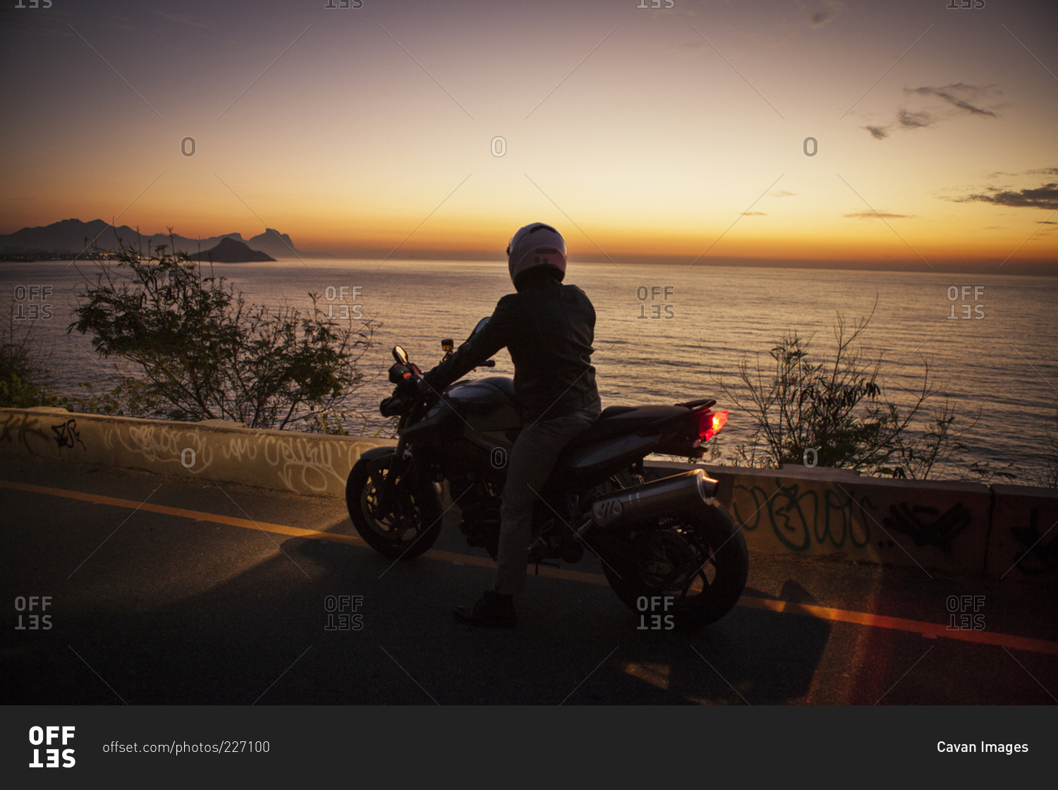 Man on motorcycle by ocean