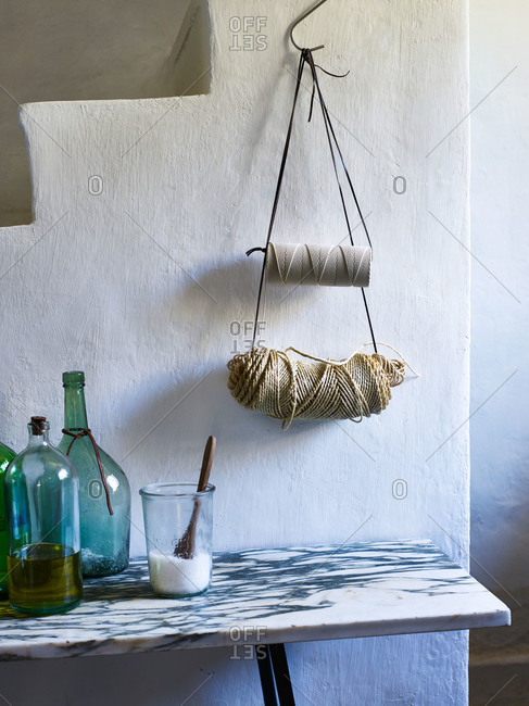 Twine hanging above marble table with bottles of olive oil and salt