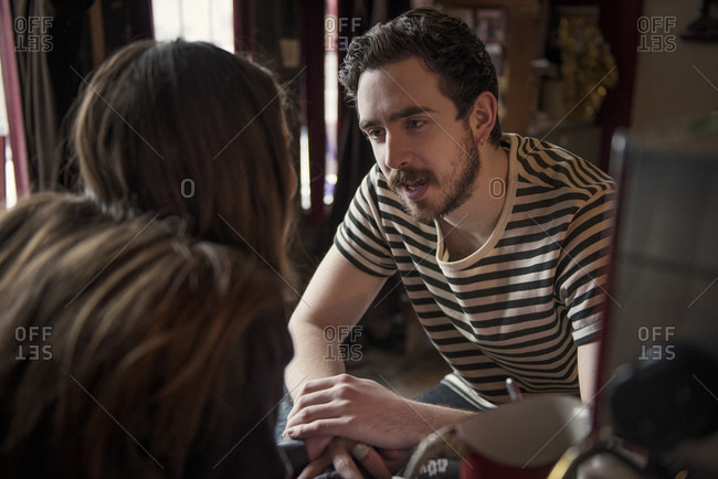 Couple lovingly gazing across cafe counter