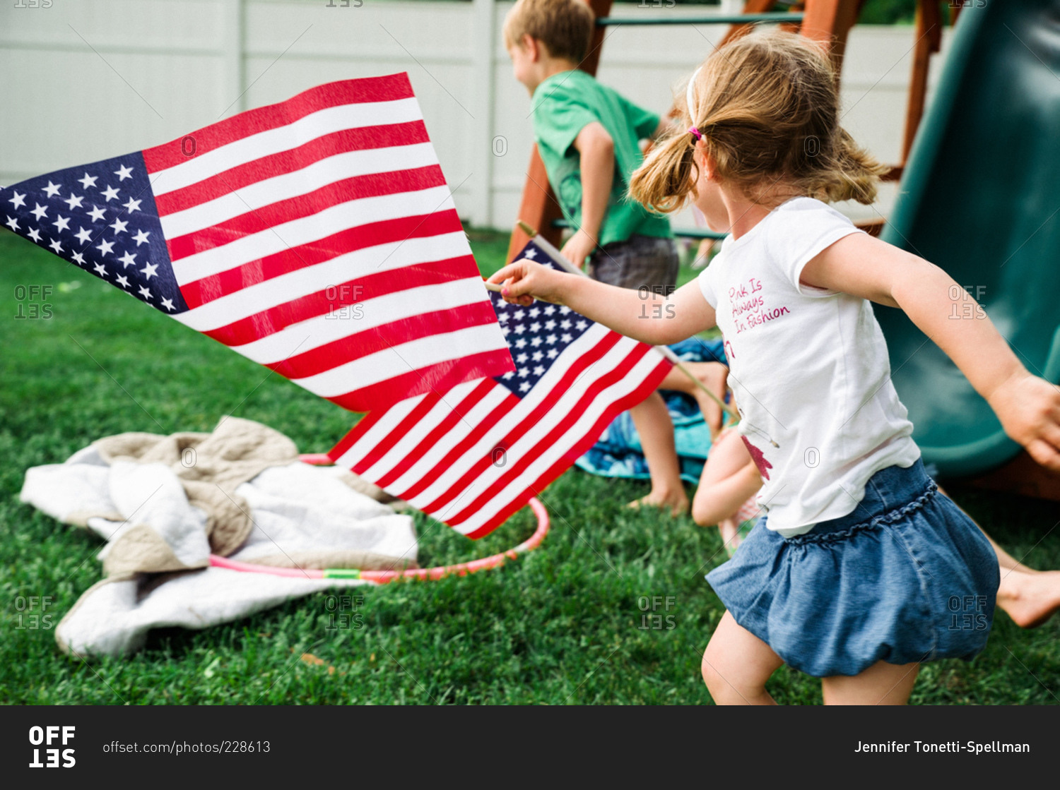 Children running in backyard with American flags