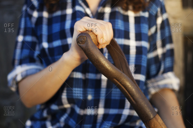 Woman in a flannel shirt holding a shovel