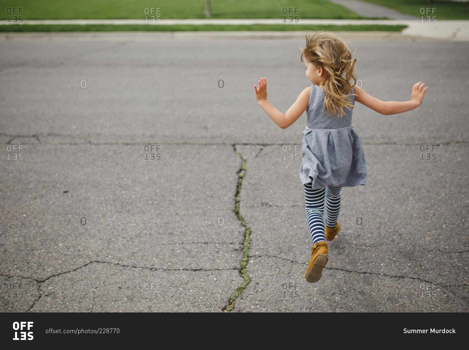 Back View Of Young Girl Running Across The Street Stock Photo Offset