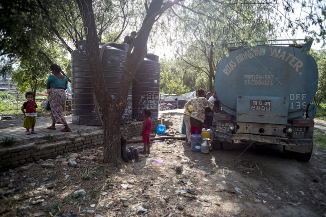 Kathmandu, Nepal - May 25, 2014: Women and children fill up tanks of water in the slums of Thapathali, Kathmandu, Nepal