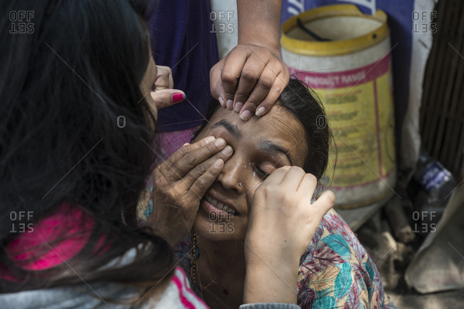 Kathmandu, Nepal - May 29, 2014: A woman gets her eyebrows threaded in the slums of Thapathali, Kathmandu, Nepal