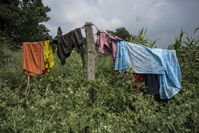 Clothes drying on barbed wire in a field in the slums of Thapathali, Kathmandu, Nepal