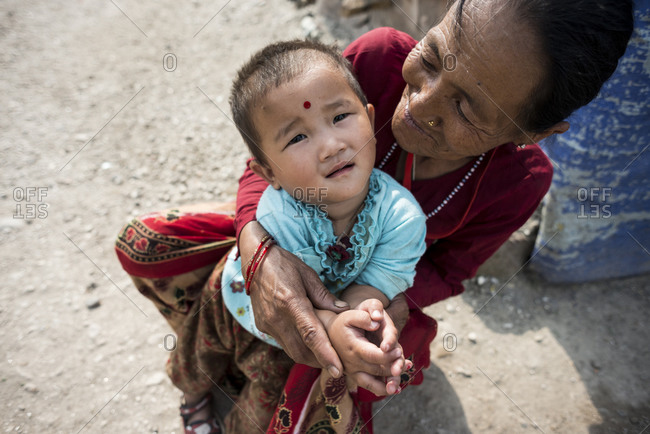 Kathmandu, Nepal - June 5, 2014: A grandmother holds her granddaughter in the slums of Thapathali, Kathmandu, Nepal