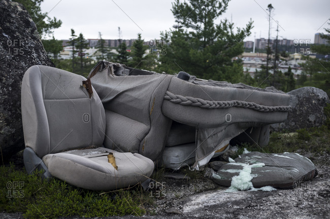 An abandoned couch on the edge of a town