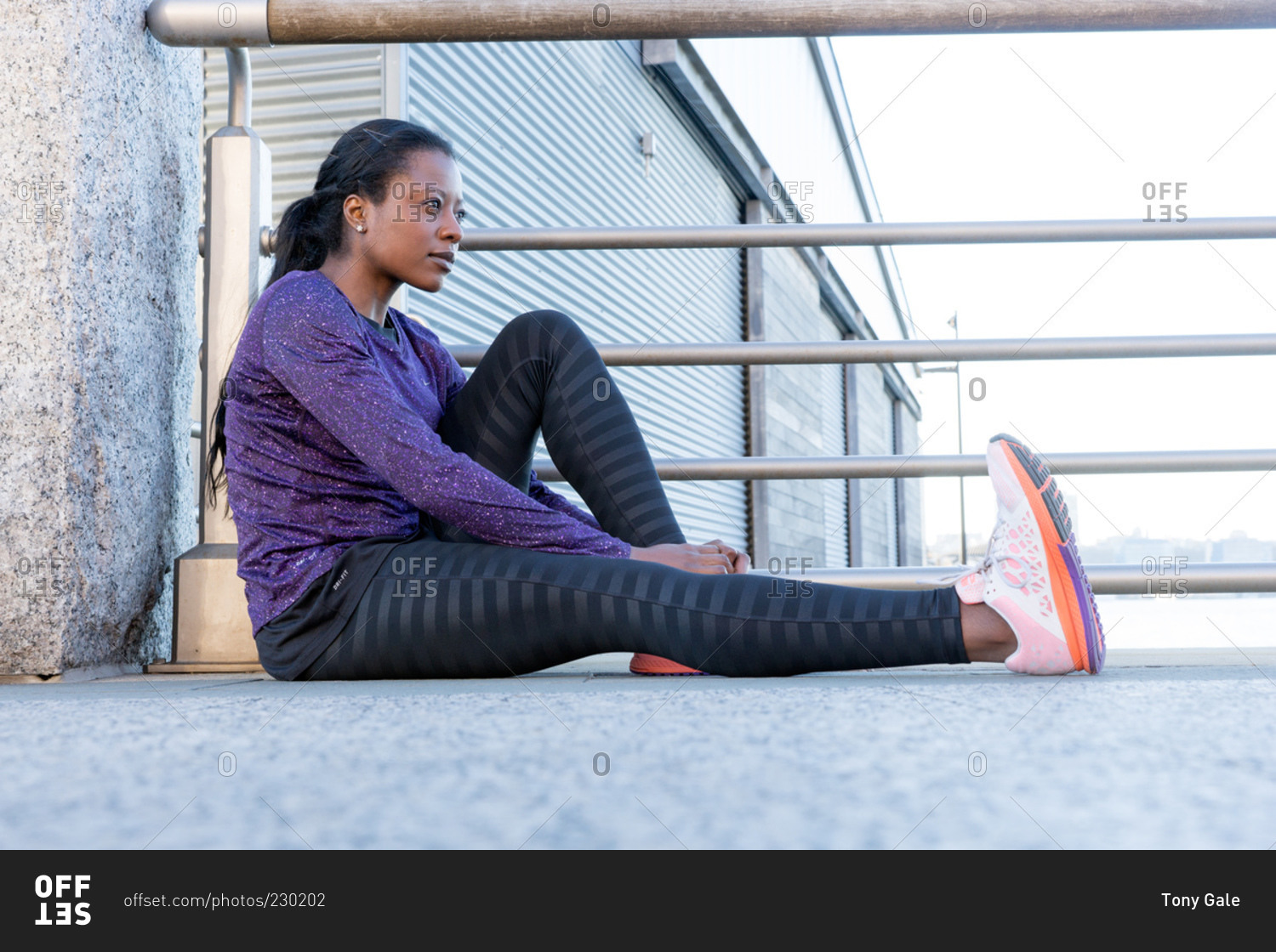 Athletic woman sitting resting by railing