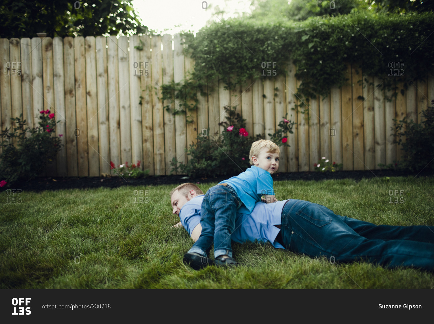 Boy wrestling with dad in yard