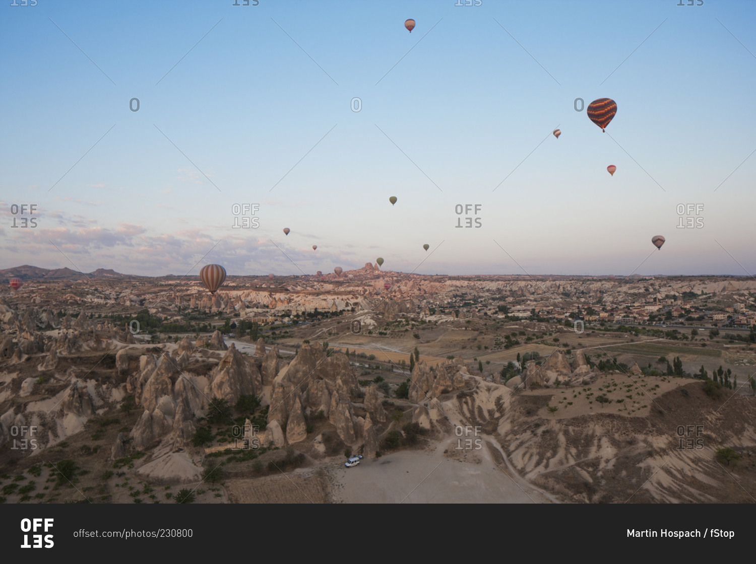Hot air balloons flying over dramatic landscape