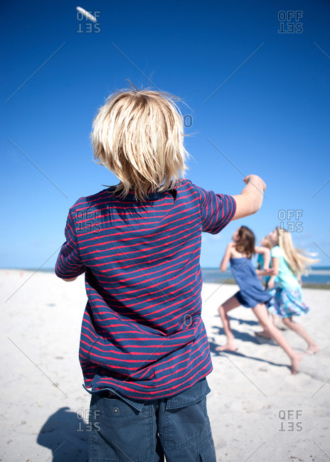 Children playing with a flying disc on a beach