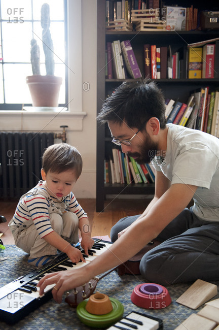 Father teaching young boy to play keyboard