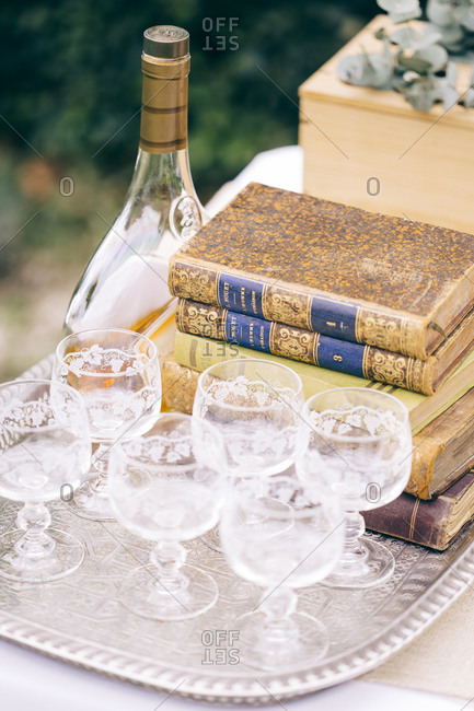 Silver tray with glasses and liquor set with books at an outdoor wedding reception