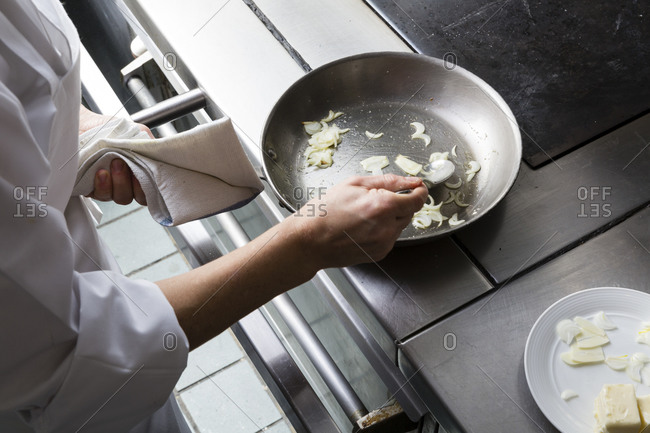 Person sauteing onions on a stove