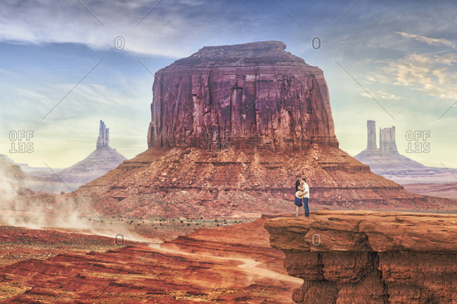 Couple kissing on a bluff in Monument Valley