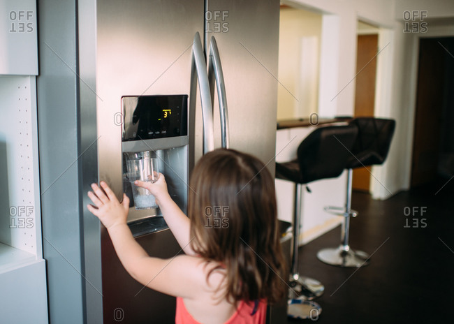 Water Dispenser from Dispenser of Home Fridge, Woman is Filling a