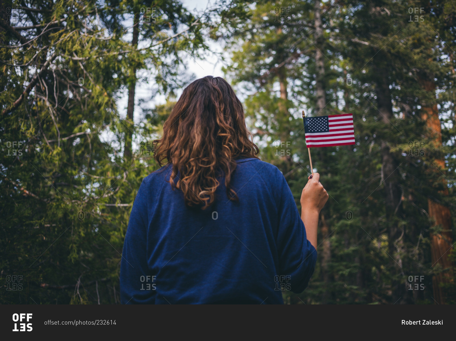Woman in forest holding an American flag