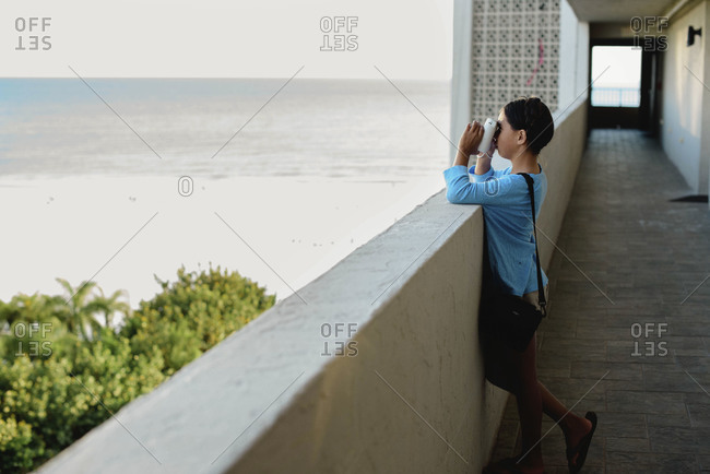 Kid taking a photo of the beach from a condominium balcony