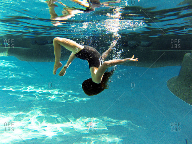 A girl does a somersault underwater stock photo - OFFSET