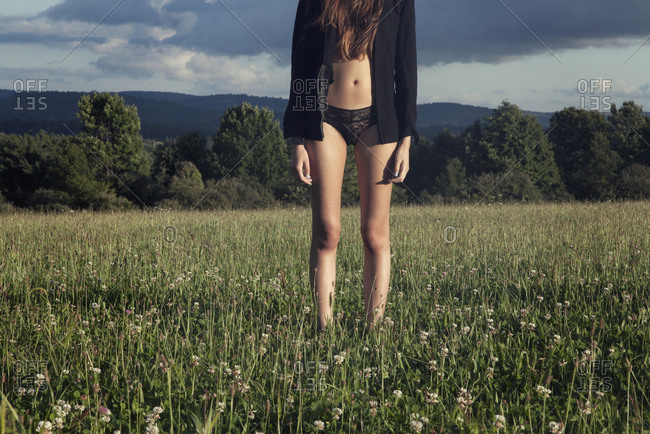 Young woman standing in underwear stock photo - OFFSET