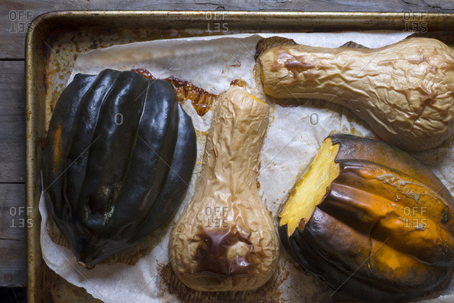 Roasted Maine butternut and acorn squash on a piece of parchment paper on a sheet tray