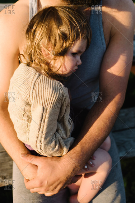 Little girl resting in her father's lap