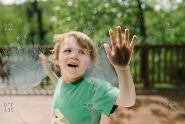 Boy leaving handprints on the window