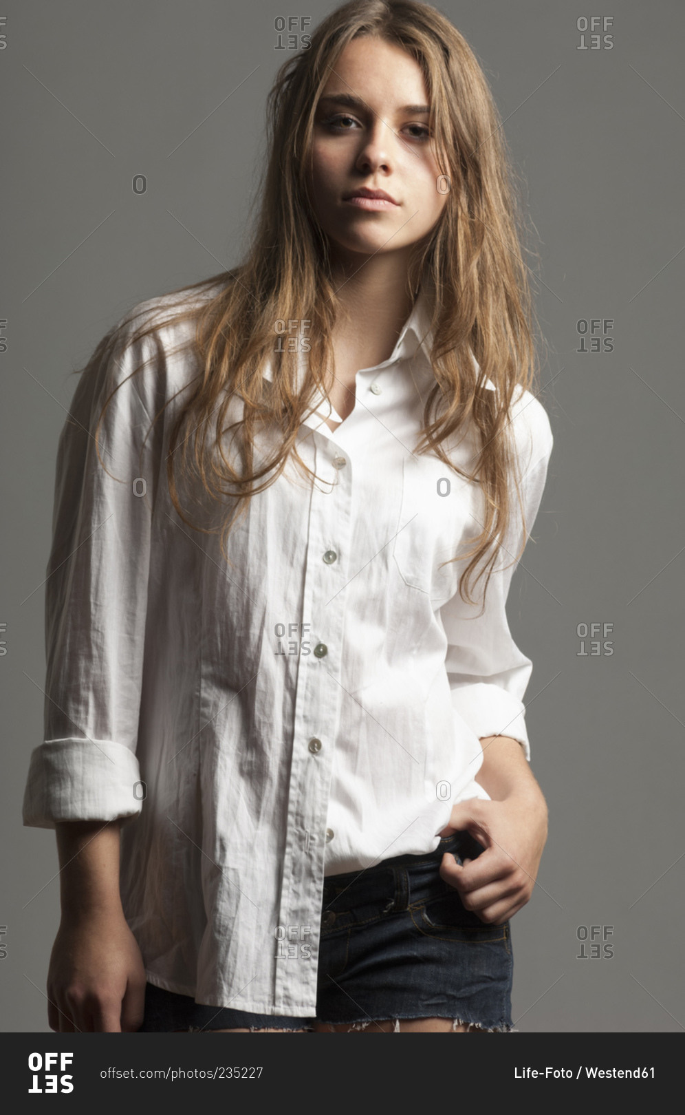 Portrait of female teenager with long brown hair wearing white blouse
