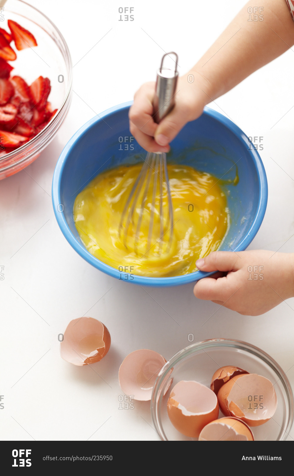 A woman whisks eggs while preparing to make french toast