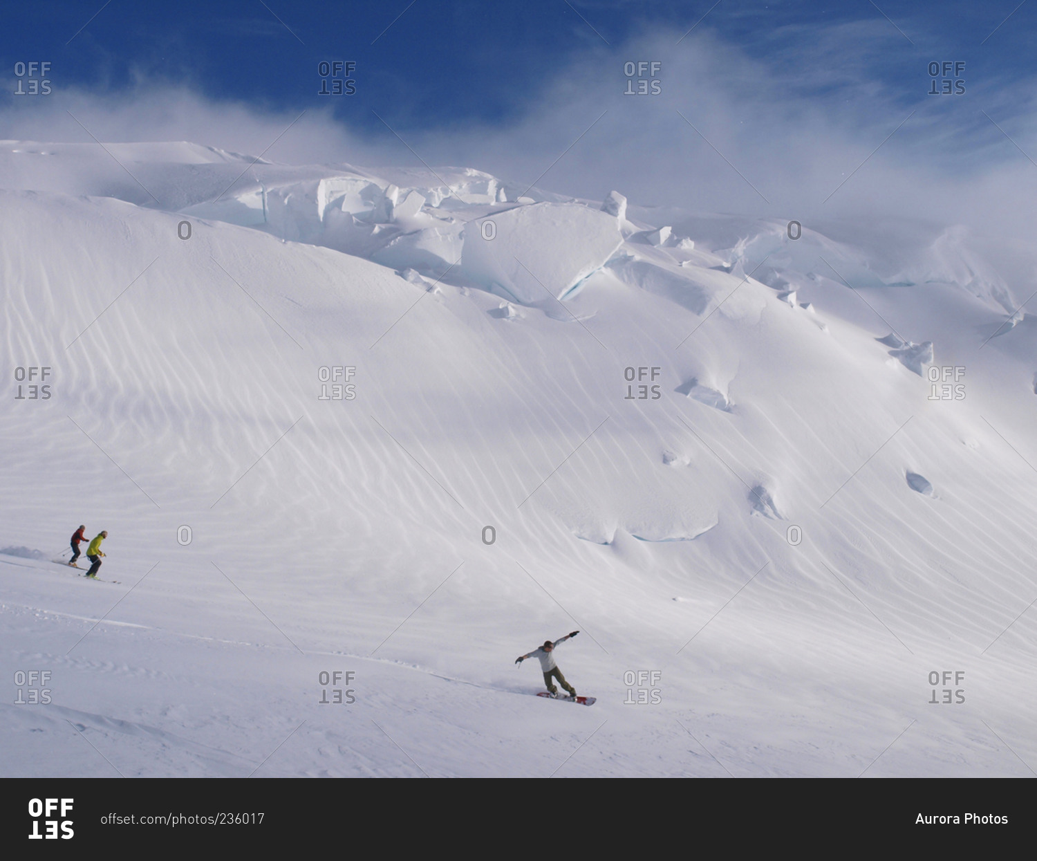 Mountaineers are skiing and snowboarding in the evening light, near 12000 feet camp on a glacier on Mount McKinley