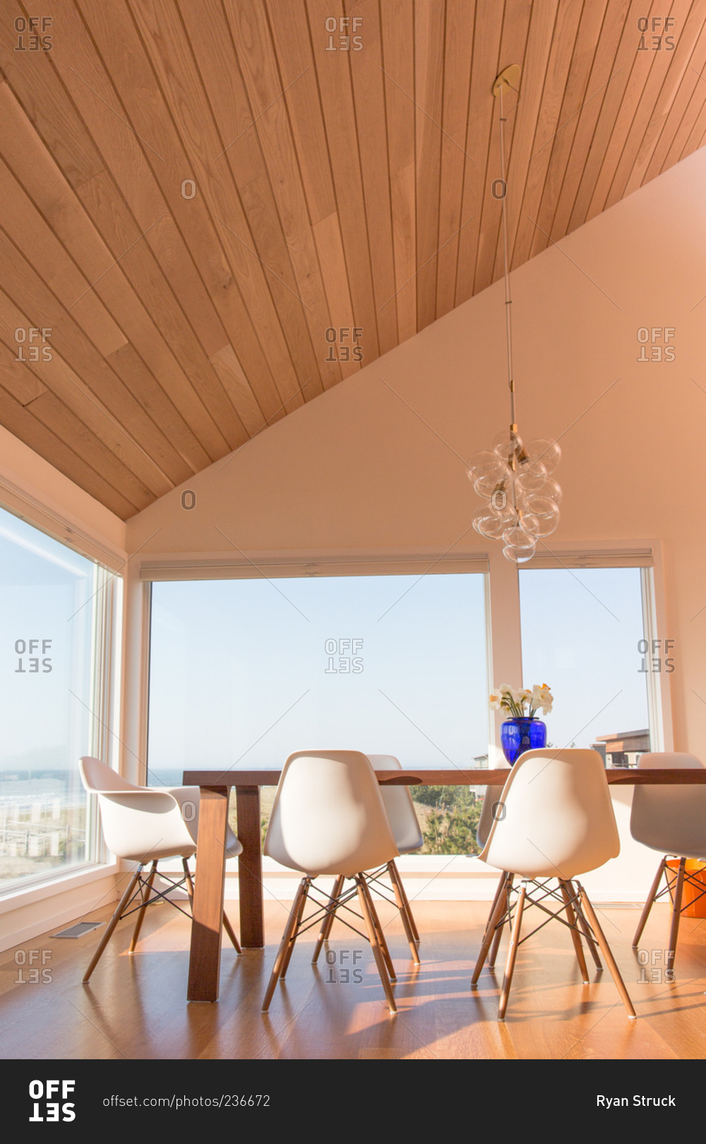 Modern dining table below a sloping ceiling in a modern beach house
