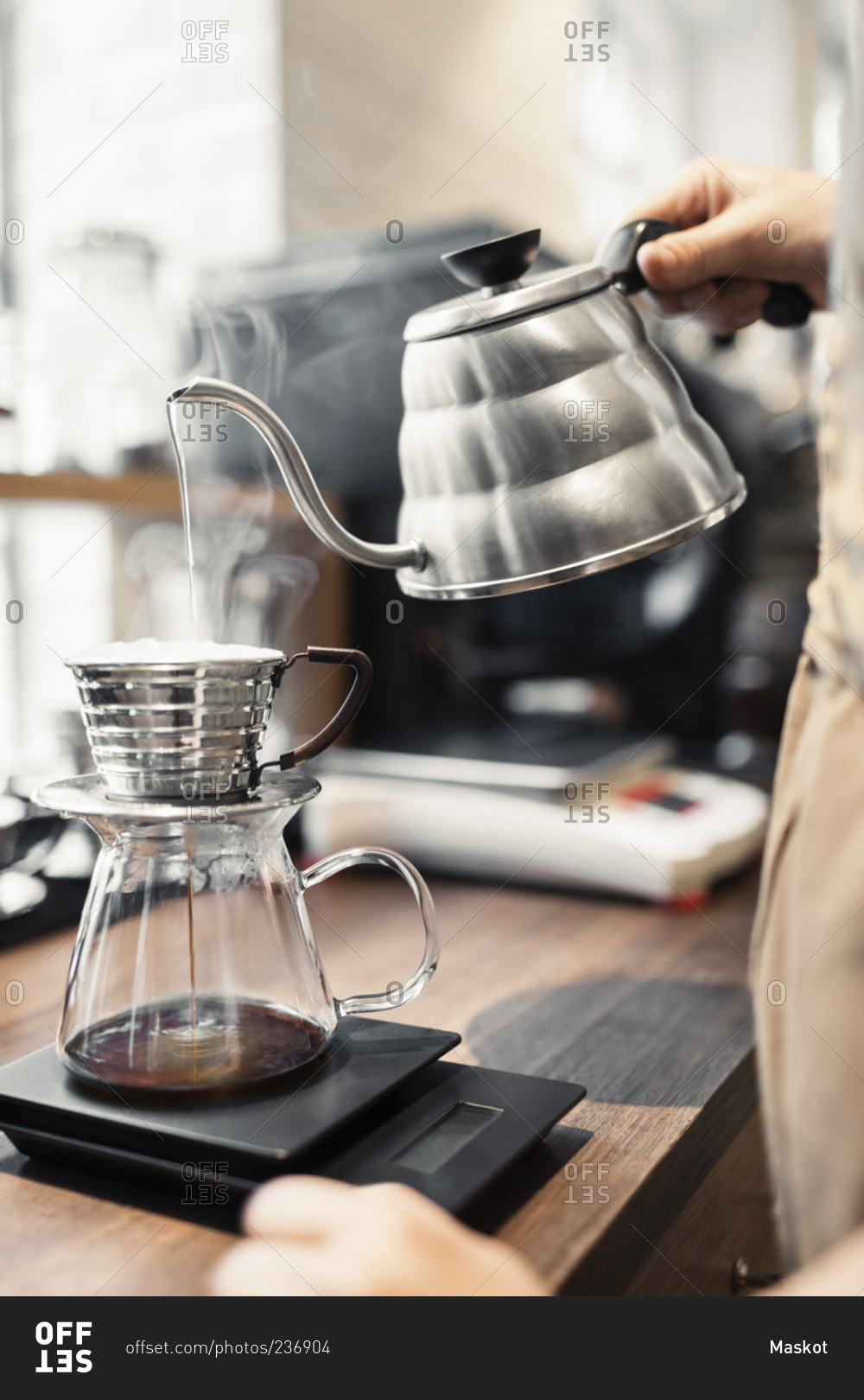 Barista pouring boiling water in coffee filter