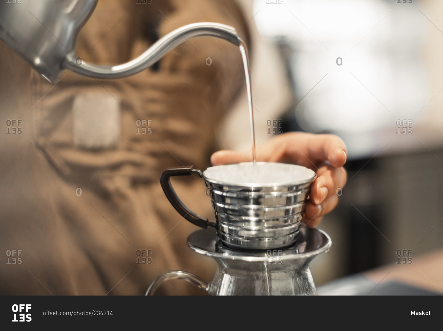 Barista pouring water in coffee cup at cafe