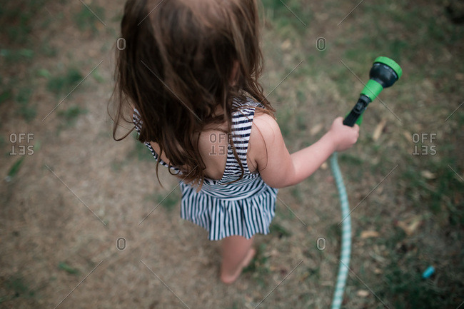 Girl in bathing suit holding hose nozzle