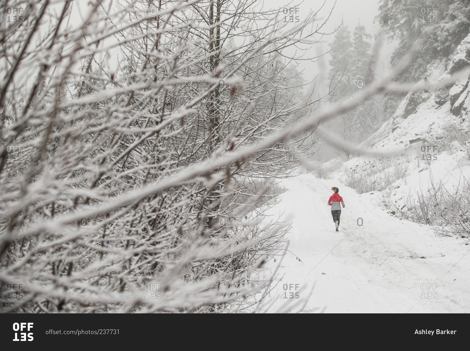 Woman running in the snow on a trail