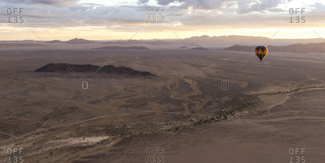 A hot air balloon flies over the Namibian desert