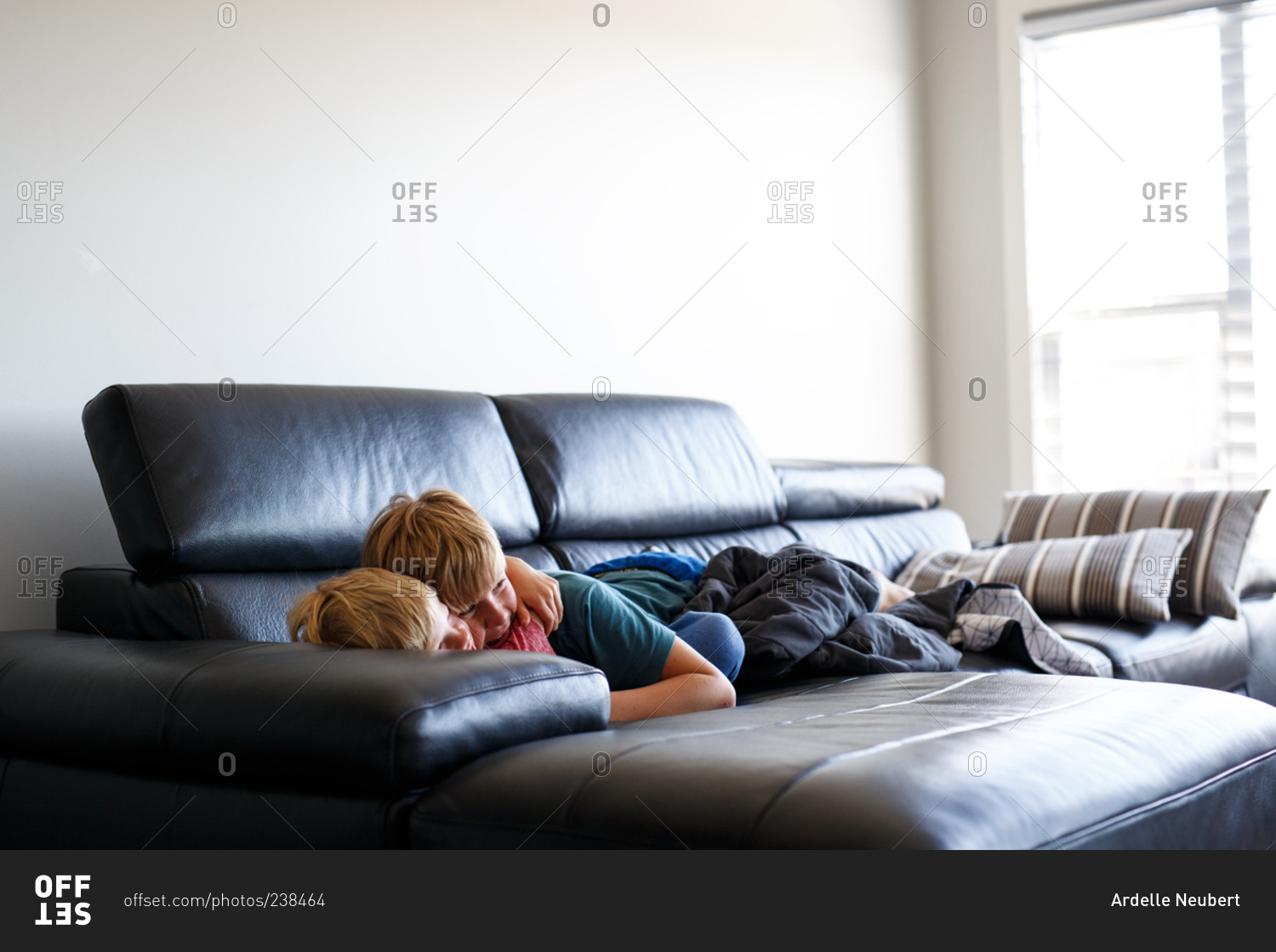 Siblings cuddling on a couch