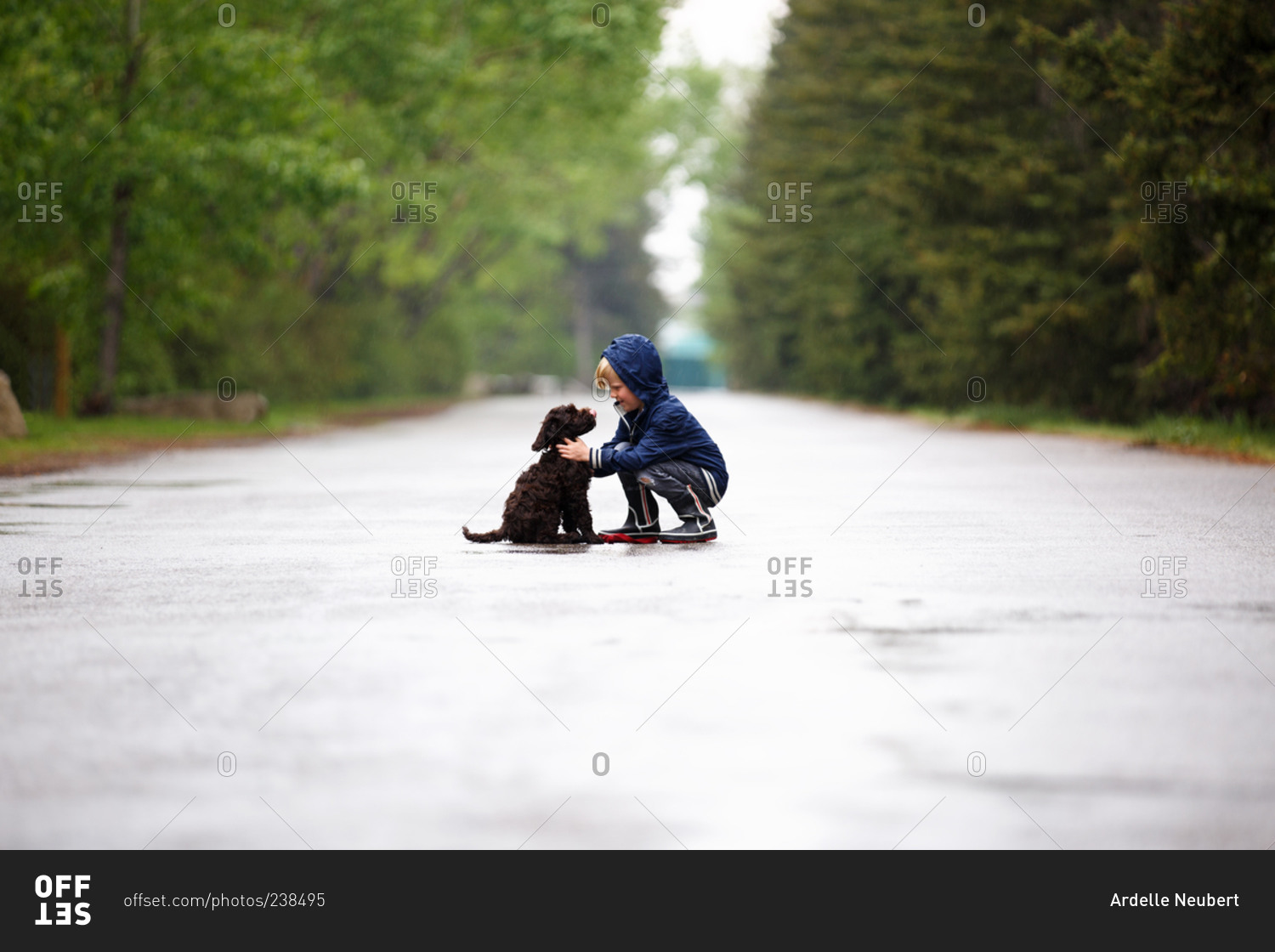 Boy with his puppy in the rain