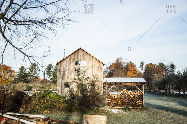 A woodshed next to a renovated barn made with mushroom wood siding