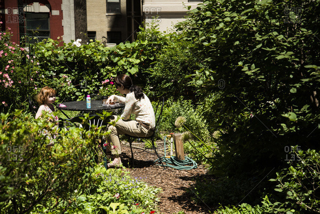 New York, NY - November 17, 2000: A mother and daughter eat a snack in a community garden