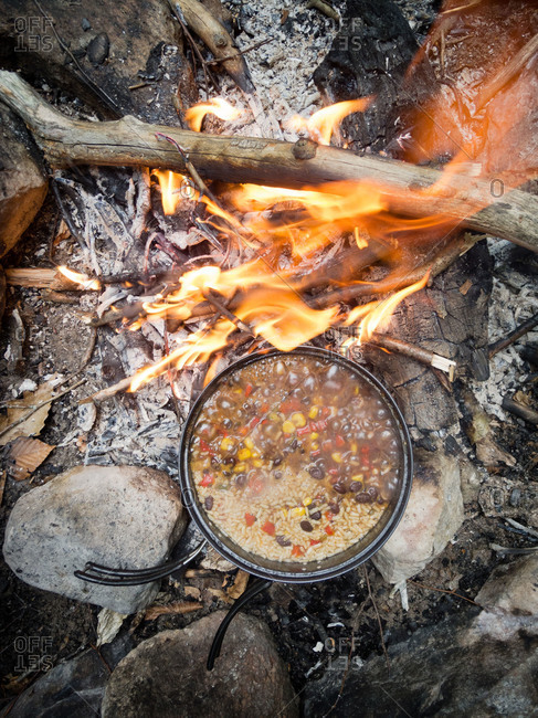 Pot of soup over campfire flames