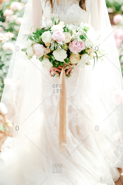 A bride holds a bouquet of roses