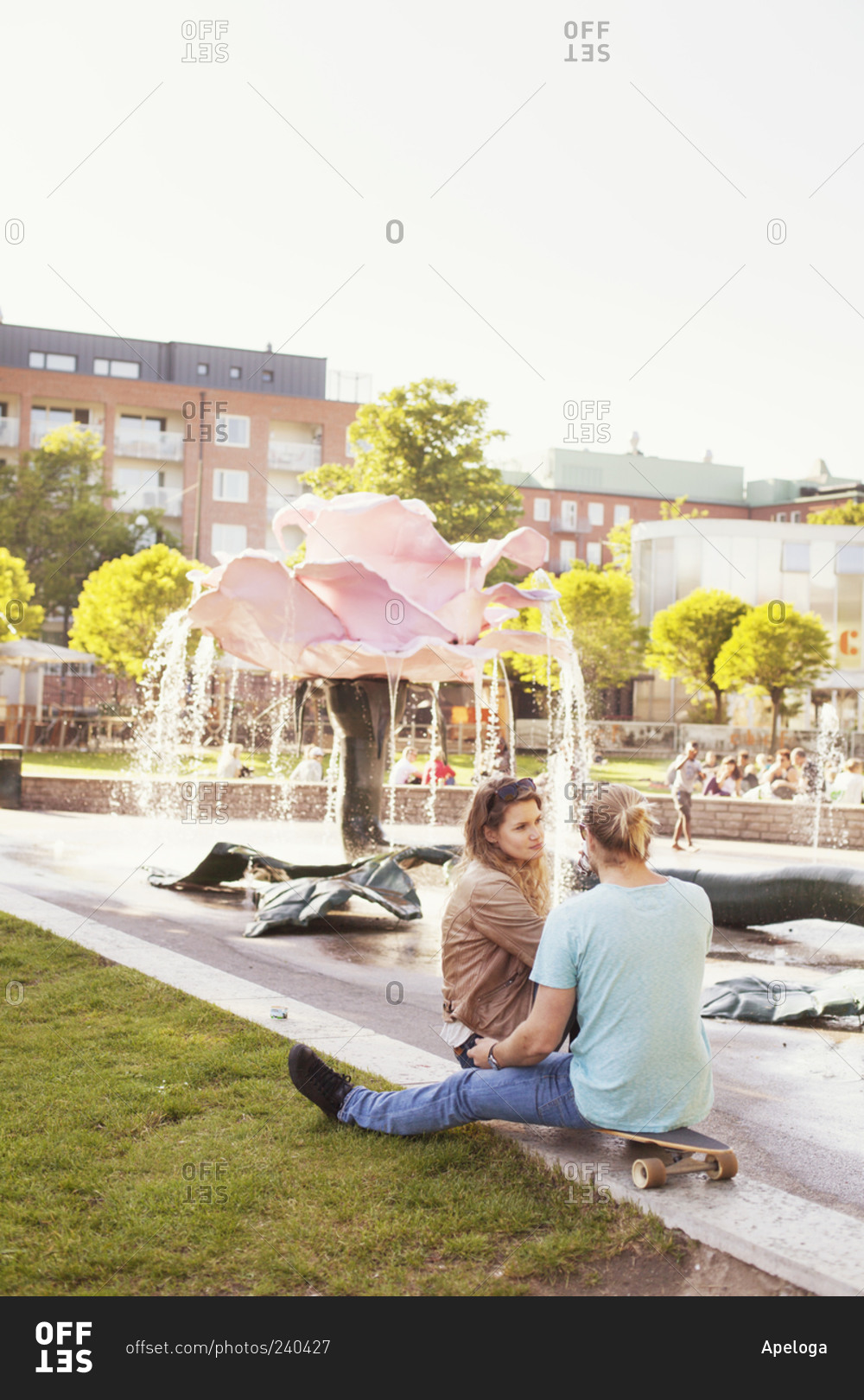 Couple sitting by fountain in park