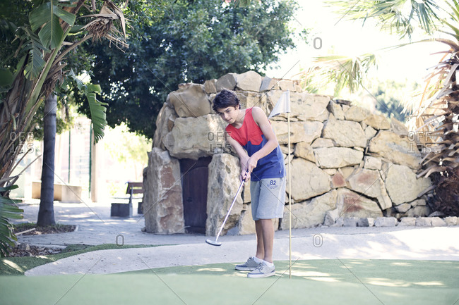 Boy playing minigolf